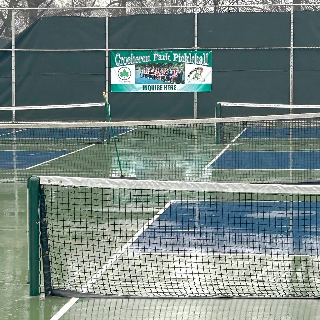 tape measure held at the centre of a pickleball net showing 34 inches